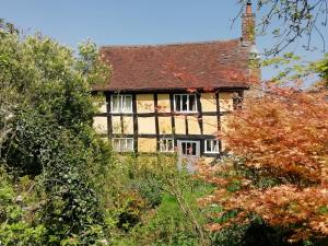 ein altes Haus inmitten der Bäume in der Unterkunft Wyre Forest Cottage in Bewdley