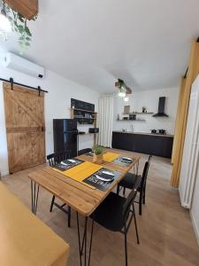 cocina y comedor con mesa de madera y sillas en lacasadicorte, en Bollate