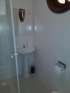 een witte badkamer met een wastafel en een spiegel bij Studio bem localizado. in Curitiba