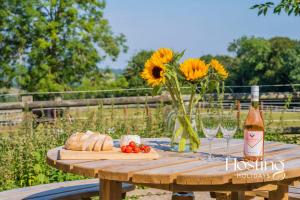 una mesa de picnic con un jarrón de girasoles y copas de vino en Walkers Hideaway In The Heart Of The Chilterns With Incredible Views, en Henley on Thames