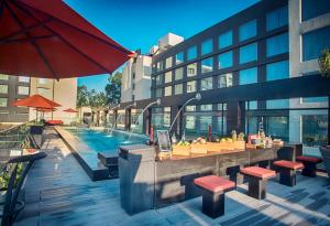 a swimming pool with a bar and tables and a building at Indore Marriott Hotel in Indore