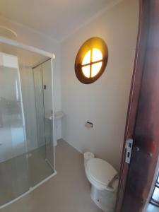 een badkamer met een toilet en een klok aan de muur bij Studio bem localizado. in Curitiba