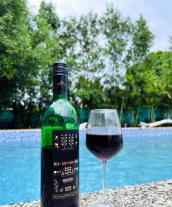 een fles wijn en een glas naast het zwembad bij BOHO BY THE BEACH Resort in Morjim