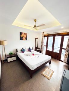 een slaapkamer met een groot bed in een kamer met ramen bij BOHO BY THE BEACH Resort in Morjim