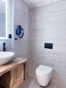 La salle de bains est pourvue de toilettes blanches et d'un lavabo. dans l'établissement Nostos luxury beach home, à Stalida