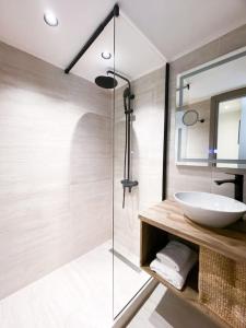 La salle de bains est pourvue d'un lavabo et d'une douche en verre. dans l'établissement Nostos luxury beach home, à Stalida