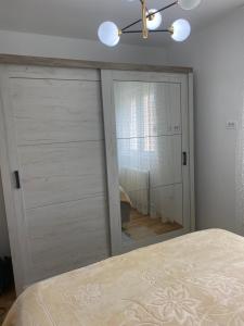 a bedroom with a mirror and a bed at Pirlitor Mountain Apartment in Žabljak