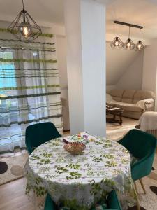 a dining room with a table and green chairs at Pirlitor Mountain Apartment in Žabljak