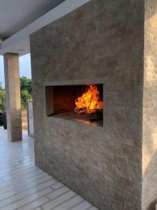 a brick fireplace with a fire in it at Villa Ramljak in Mostar