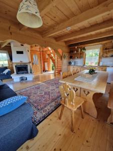 ein großes Wohnzimmer mit einem großen Tisch in einer Blockhütte in der Unterkunft Dom Letnisowkowy Basiówka in Bodzentyn