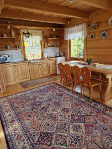 eine Küche mit einem Tisch und Stühlen in einer Hütte in der Unterkunft Dom Letnisowkowy Basiówka in Bodzentyn