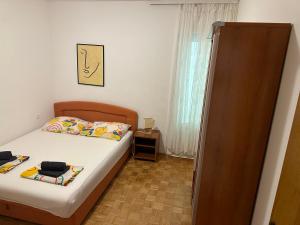 a small bedroom with a bed and a window at Apartment Jelić in Duće