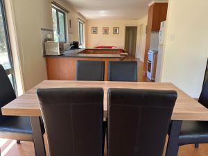 una cucina con tavolo in legno e sedie nere di Bliss in Venus Bay - Welcome to 2025! a Venus Bay