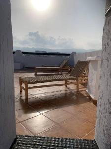 dos bancos sentados en la parte superior de un techo en Maison Alcudia Smir, Tetouan, Mer Méditerranée, en Fnidek
