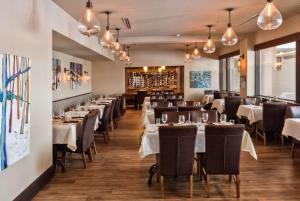 une salle à manger avec des tables, des chaises et des lumières dans l'établissement Georgian Bay Hotel Trademark Collection by Wyndham, à Collingwood