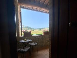 Una habitación con una mesa y sillas y una ventana. en Agriturismo la Peschiera, en Casole dʼElsa