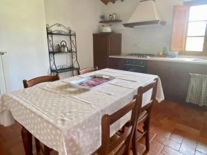 cocina con mesa y mantel blanco en Agriturismo la Peschiera, en Casole dʼElsa 3 fotos más