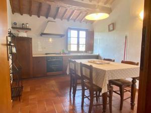 cocina con mesa, sillas y mesa en Agriturismo la Peschiera, en Casole dʼElsa