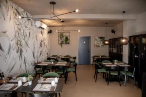 a restaurant with wooden tables and green chairs at White Hill Apartment in Zadar