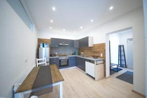 a kitchen with blue cabinets and a wooden floor at Burgblick-merzalben in Merzalben