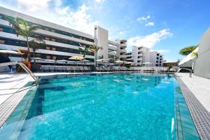 a large swimming pool in front of a building at HOVIMA Suites Costa Adeje in Adeje