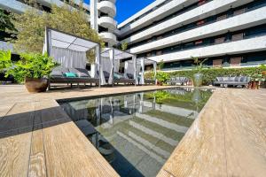 a building with a pool in front of a building at HOVIMA Suites Costa Adeje in Adeje