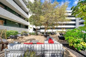 a patio with couches and chairs in front of a building at HOVIMA Suites Costa Adeje in Adeje