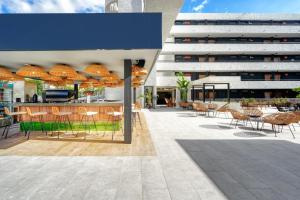 an outdoor patio with chairs and tables and umbrellas at HOVIMA Suites Costa Adeje in Adeje