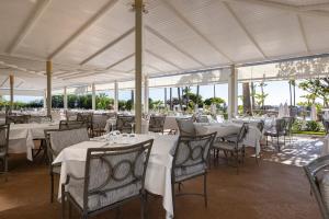 un ristorante con tavoli e sedie con tovaglia bianca di Hipotels Barrosa Palace & Spa a Chiclana de la Frontera