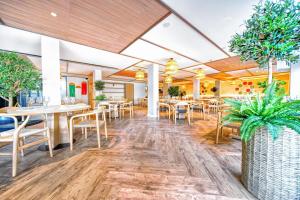 a restaurant with tables and chairs and potted plants at HOVIMA Suites Costa Adeje in Adeje