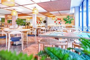 a restaurant with tables and chairs and plants at HOVIMA Suites Costa Adeje in Adeje