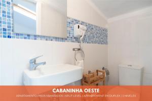 y baño con lavabo, espejo y aseo. en Cabanas do avô João, en Nazaré