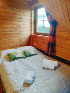 1 dormitorio con 1 cama con 2 toallas en Zbójecko Chata, en Bukowina Tatrzańska