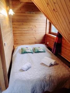 um quarto com uma cama num chalé de madeira em Zbójecko Chata em Bukowina Tatrzańska