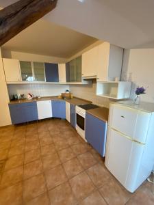 a kitchen with white appliances and blue cabinets at Restaurace Bowling Rakovec in Řepiště