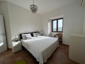 een witte slaapkamer met een groot bed en een raam bij Panorama Mare e Monti in Spigno Saturnia