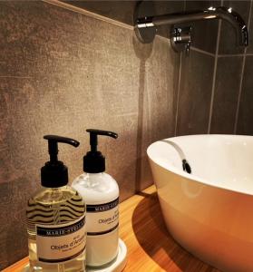 a bathroom with two bottles of soap and a sink at B&B Loft-13 in Opende
