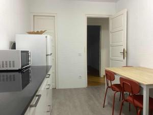 een keuken met een witte koelkast en een tafel met stoelen bij Apartamento Ayla Catedral in Pamplona