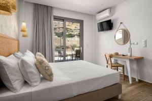 a bedroom with a bed and a table and a desk at Kayy Apartments 3 in Matala in Matala