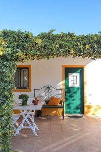 a patio with a table and a bench and a building at Casinha Robusto 