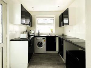 uma cozinha com uma máquina de lavar roupa e uma máquina de lavar louça em Nicely Decorated 4BR, w/ Foosball Table and more! em Liverpool