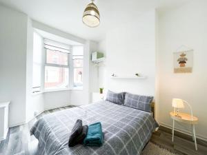 a white bedroom with a bed with a blue blanket at Nicely Decorated 4BR, w/ Foosball Table and more! in Liverpool