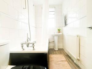 uma casa de banho branca com um lavatório e um WC em Nicely Decorated 4BR, w/ Foosball Table and more! em Liverpool