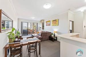 a kitchen and living room with a table and chairs at Aircabin - Parramatta - Free Parking - 1 Bed Apt in Sydney
