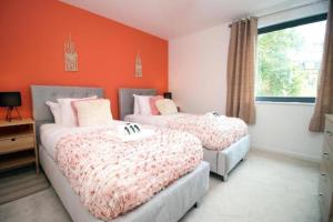 two beds in a bedroom with an orange wall at Bristol Short Stays College Green, 2 Bed Parking in Bristol