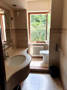 a bathroom with a sink and a window and a toilet at Agriturismo nelle Marche in Montalto delle Marche
