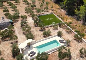 een luchtzicht op een zwembad en een voetbalveld bij Villa Mista in Sutivan