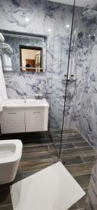 a bathroom with a toilet and a sink at Hazmurat Hotel in Gjirokastër