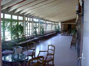 uma grande sala com mesas, cadeiras e janelas em Hotel Du Parc em Sancoins