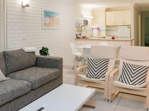 sala de estar con sofá y sillas y cocina en Trickett Gardens Holiday Inn, en Gold Coast